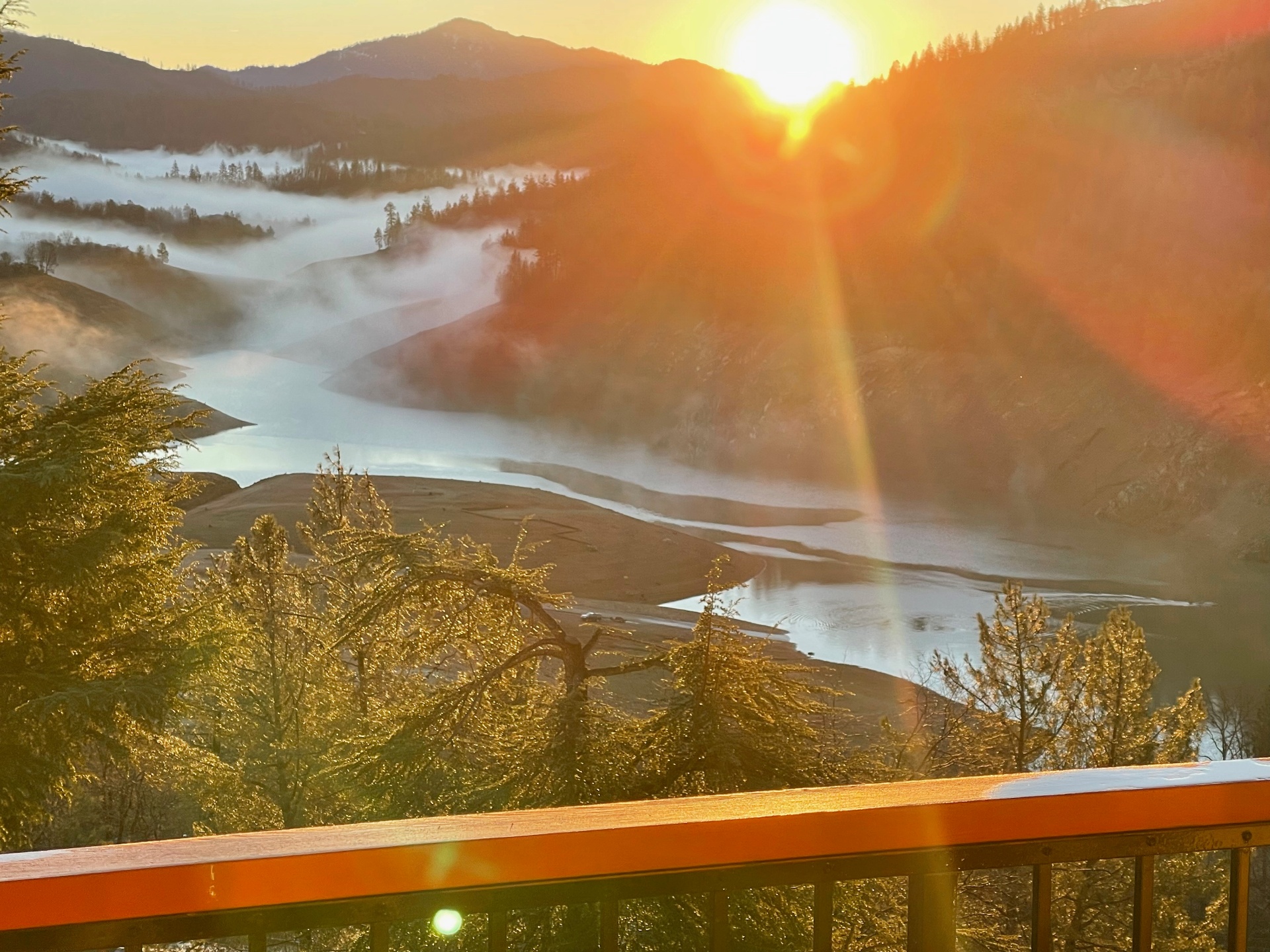 Soft sunrise mist rising over still lake water